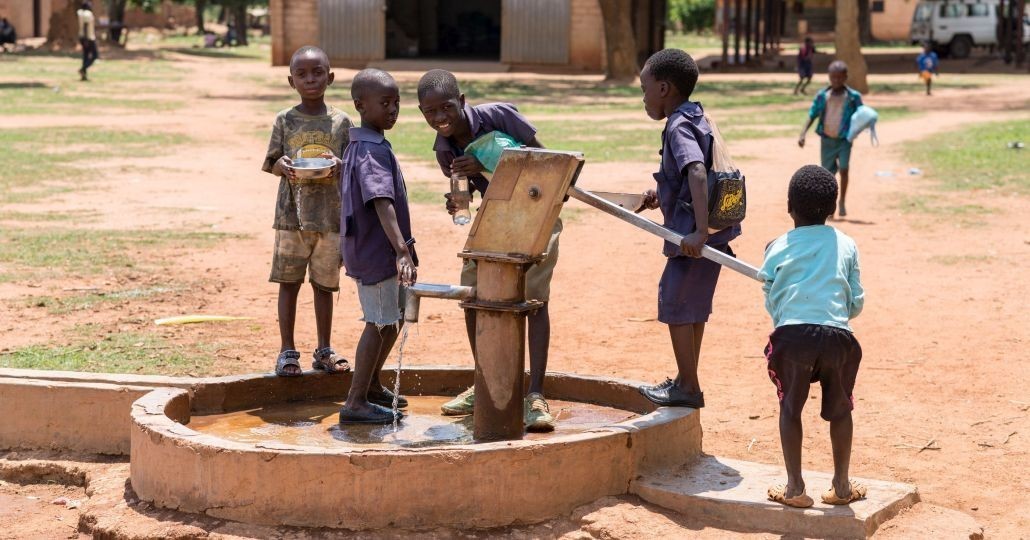 Kinder trinken Wasser aus einem Brunnen._©GEMEINSAM FÜR AFRIKA