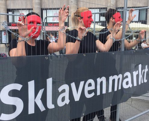 Sklavenmarkt in Köln. Drei "Sklav*innen" im Käfig. ©GEMEINSAM-FUER-AFRIKA