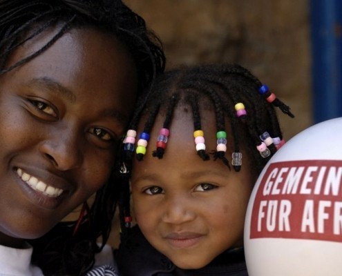 Eine Frau mit ihrem Kind und einem Luftballon in Kenia_©Gemeinsam für Afrika