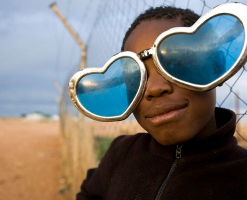 Eine Flüchtlingskind mit selbstgebastelter Herzbrille im Camp Osire, Angola. Eine Flüchtlingskind mit selbstgebastelter Herzbrille im Camp Osire, Angola._©UNHCR / Brandon Bannon