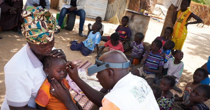 Optiker untersucht kleines Kind auf Trachome (Senegal)
